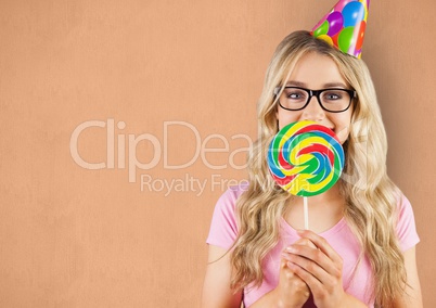 Portrait of female hipster covering mouth with candy against orange background