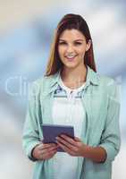 Happy female hipster holding digital tablet against blurred background