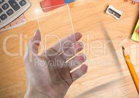 Hand with glass screen on table with objects