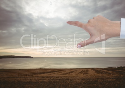 Hand Touching evening sky over landscape