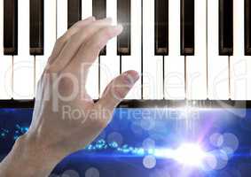 Hand Touching Piano keys with sparkling lights