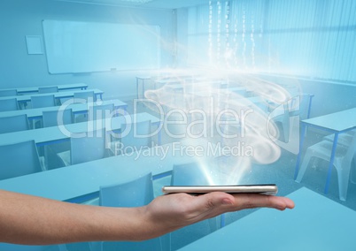 Hand holding a glass tablet in blue classroom