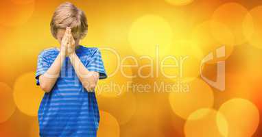 Boy praying against bokeh