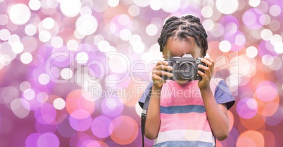 Girl using digital camera over bokeh