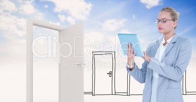 Businesswoman using tablet PC by doors against sky