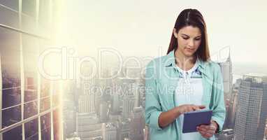 Casual businesswoman using tablet PC against city