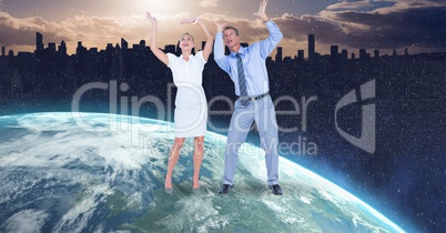 Business people with arms raised on globe