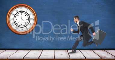 Businessman running with clock mounted on wall