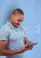 Male hipster using digital tablet against blue background
