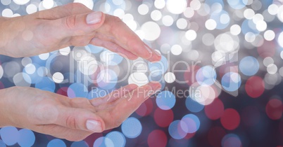 Cropped image of hands against glowing bokeh