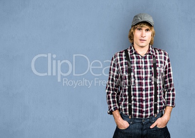 Male hipster with hands in pockets over blue background