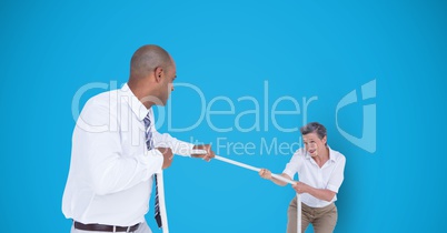 Business people playing tug of war over blue background