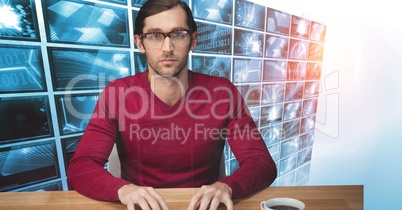 Hacker sitting at desk against monitors in background