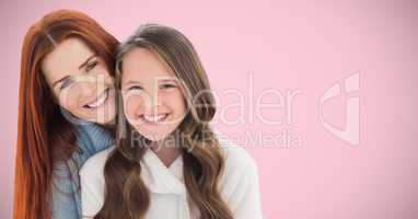 Mother and daughter against pink background