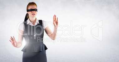Business woman blindfolded against white wall and flare