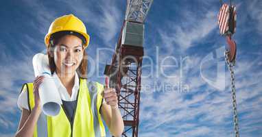Female architect showing thumbs up against crane