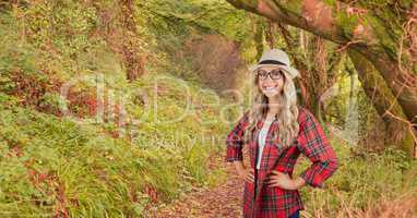 Female hipster with hands on waist in forest