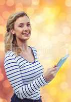 Smiling woman holding tablet PC over blur background