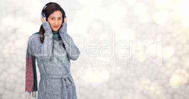 Woman in winter coat listening to music on headphones