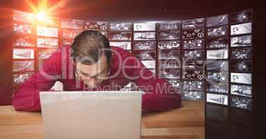 Male hacker using laptop against screens
