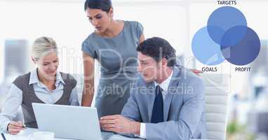 Male and female colleagues using laptop by graphics