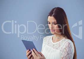 Woman with long brown hair using tablet PC over blue background
