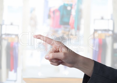 Hand pointing in  air of  clothes retail store