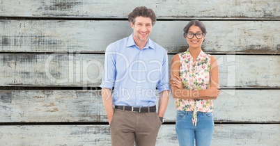Confident business people standing against wooden wall