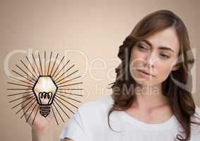 Woman drawing lightbulb doodle with flare against cream background
