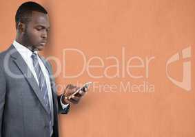 Businessman using mobile phone over peach background
