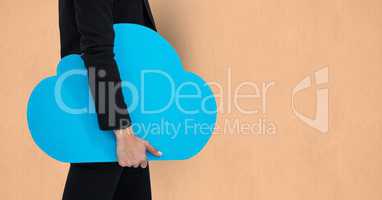 Midsection of businesswoman holding cloud shape over beige background