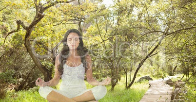 Double exposure of woman meditating in forest