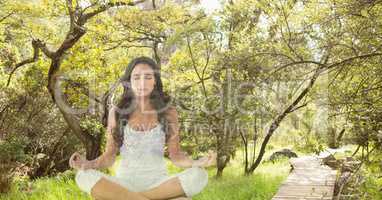 Double exposure of woman meditating in forest