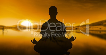 Double exposure of person meditating with lake in background during sunset