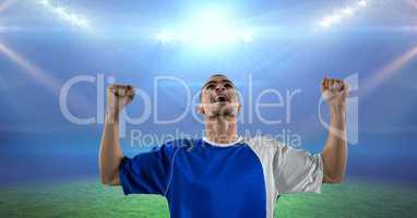 Soccer player celebrating victory in illuminated stadium