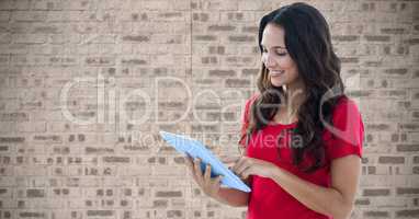 Woman using tablet PC against wall