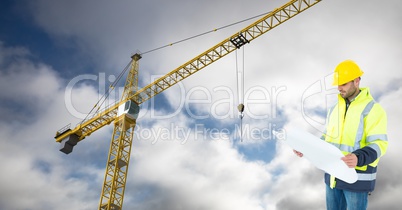 Architect holding blueprint against crane and sky