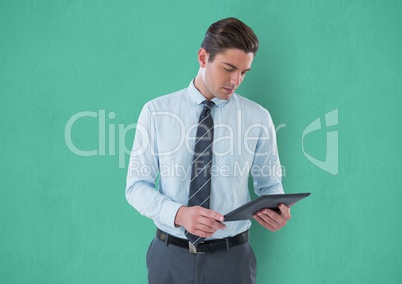 Businessman using digital tablet against green background