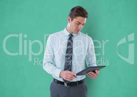 Businessman using digital tablet against green background