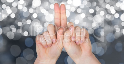 Cropped image of hands against glowing bokeh