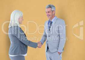 Business people shaking hands against yellow background