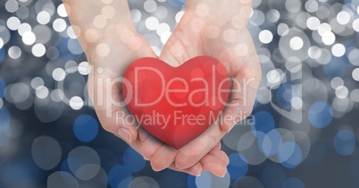 Cropped image of female's hands holding heart shape over bokeh