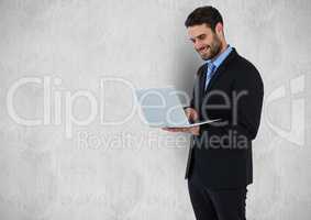 Happy businessman using laptop against gray background