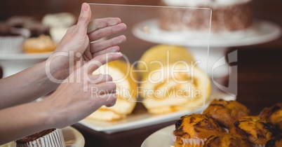 Hands taking picture of dessert with transparent device in coffee shop