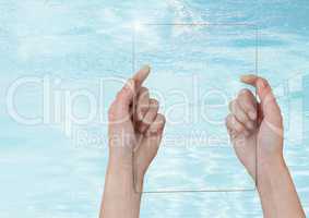 Hand holding glass screen over clear blue water
