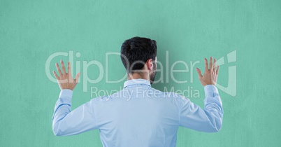 Rear view of businessman touching colored background