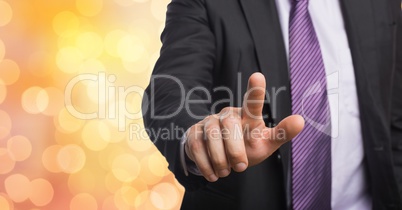 Midsection of businessman touching imaginary screen over bokeh