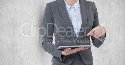 Midsection of businesswoman pointing at digital tablet