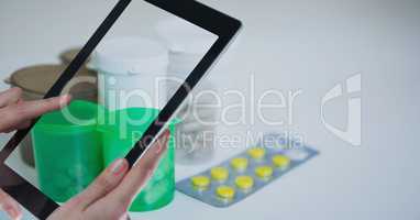 Hands photographing medicines through tablet PC