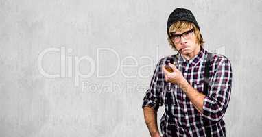 Male hipster smoking pipe against wall